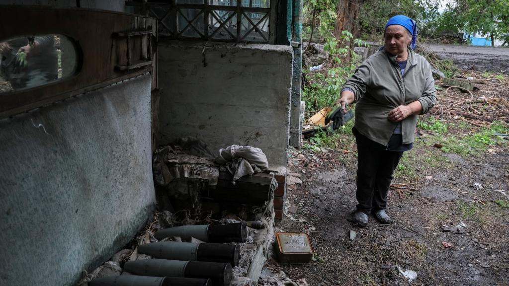 Una mujer señala los misiles que han destruido su casa en Járkov.