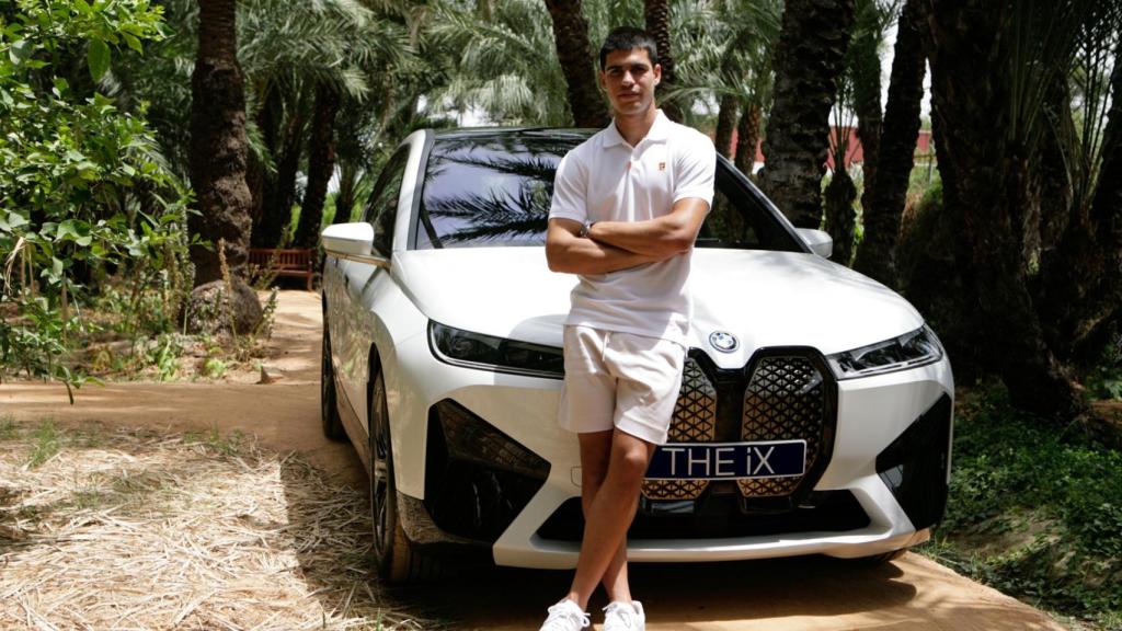 Carlos Alcaraz junto con su nuevo BMW iX.