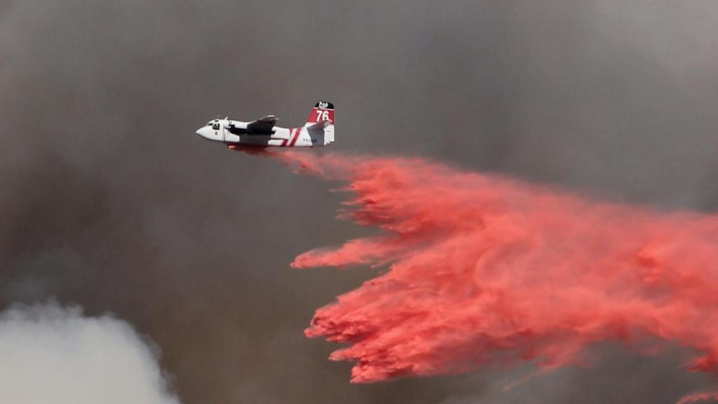 Avión expulsa compuestos contra incendios.