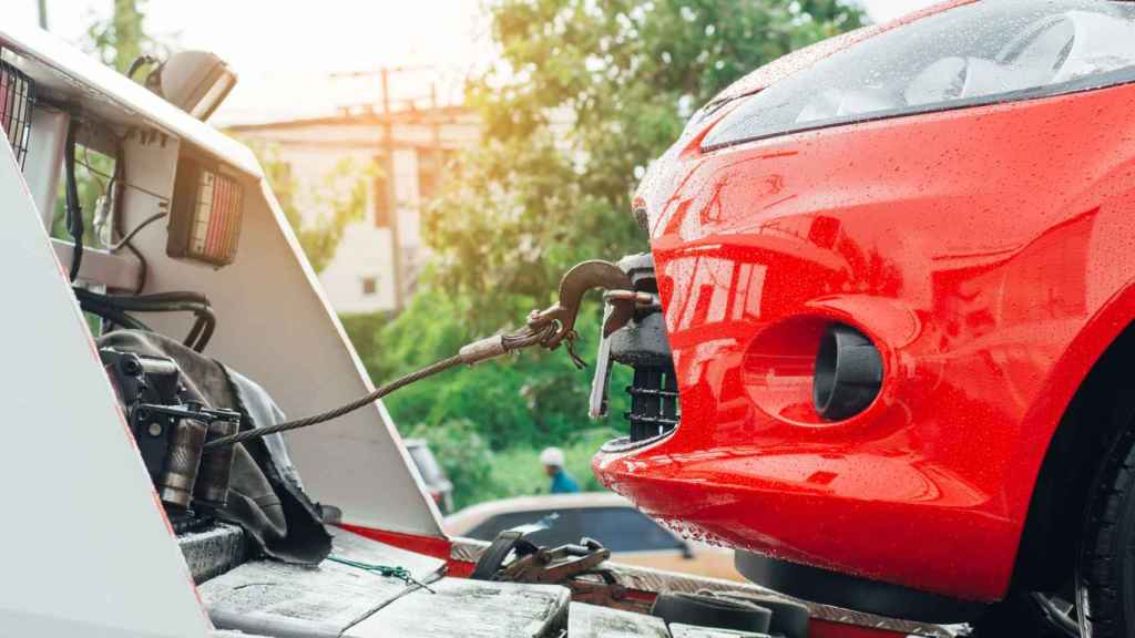 Imagen de archivo de una grúa remolcando un coche.