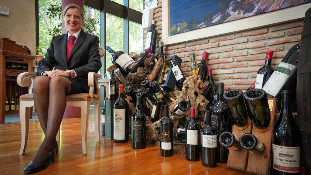 La profesora de La Cónsula, Isabel, junto a unas botellas de vino.