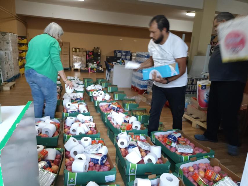 Los voluntarios preparan las cajas con alimentos y material higiénico