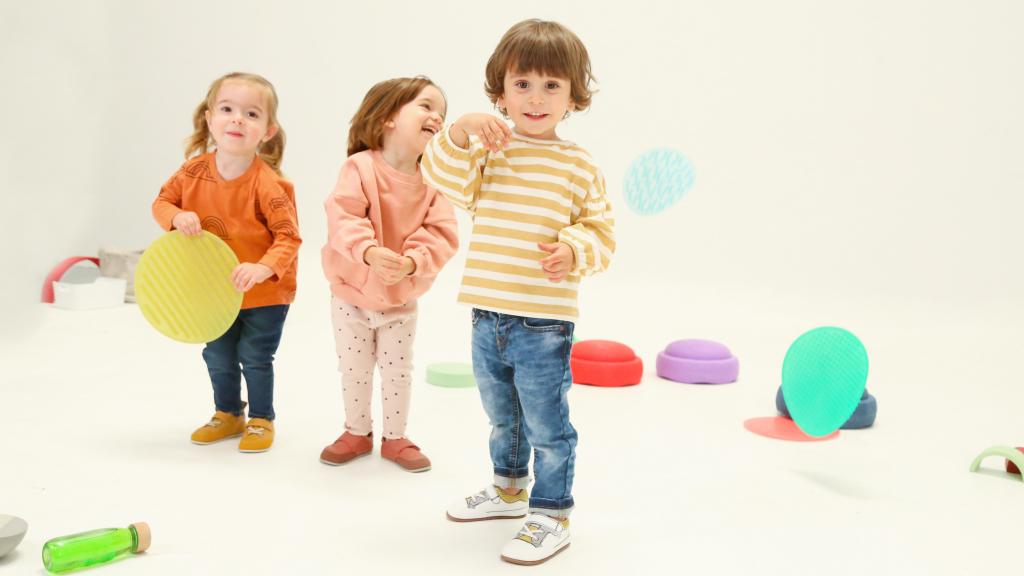 Tres niños jugando mientras visten el calzado de Zapato Feroz.