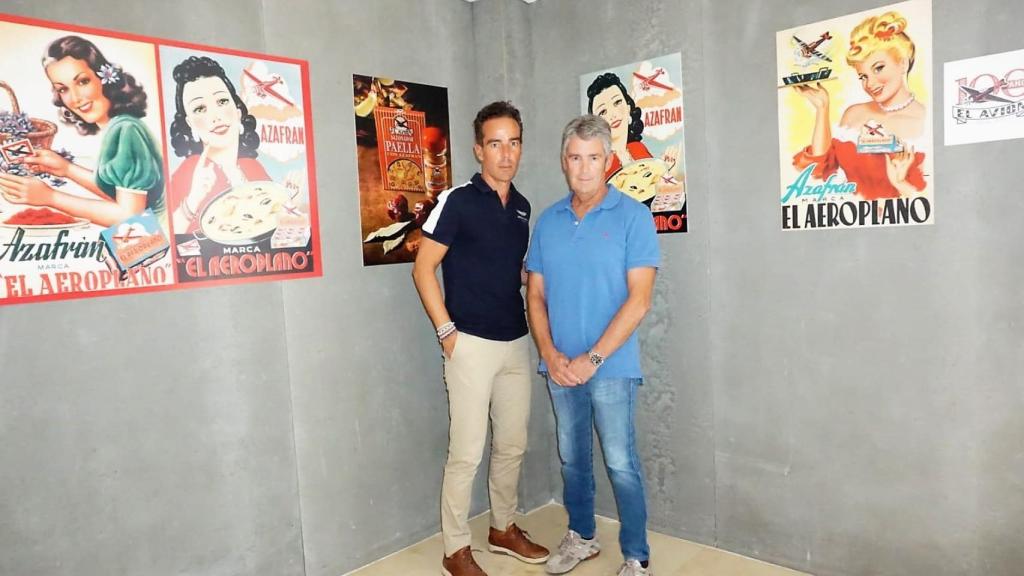 Los dos hermanos posan con los carteles promocionales de los productos.