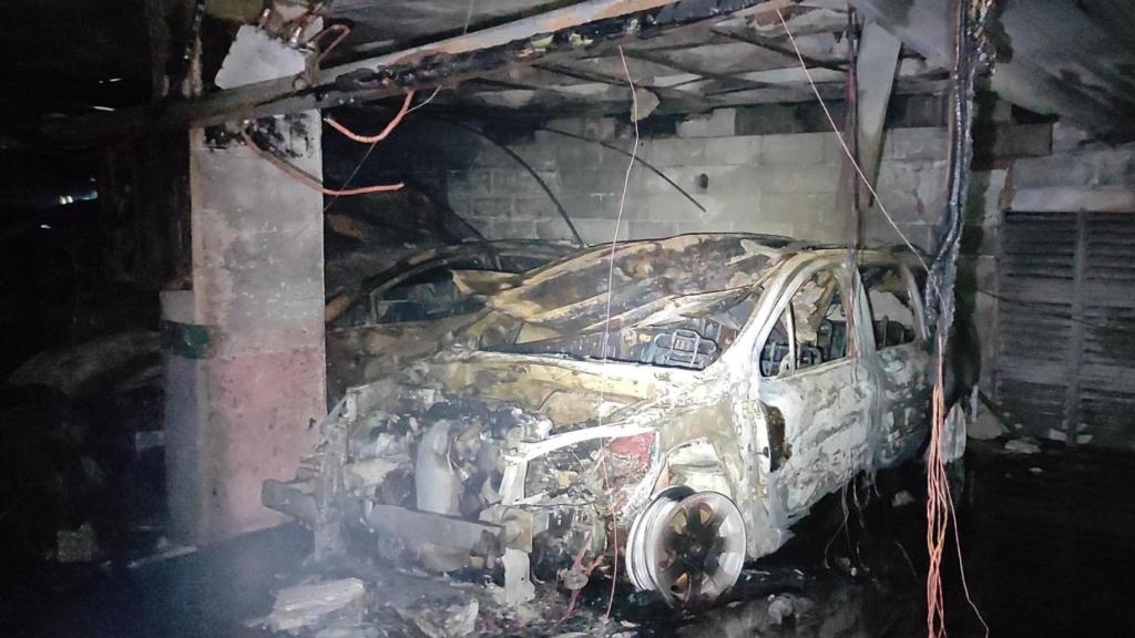 Imagen de uno de los vehículos calcinados tras el incendio en el parking del Orzán.