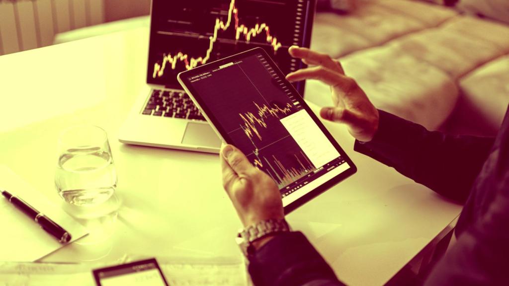 Un inversor consulta la bolsa en una tableta y su ordenador portátil.