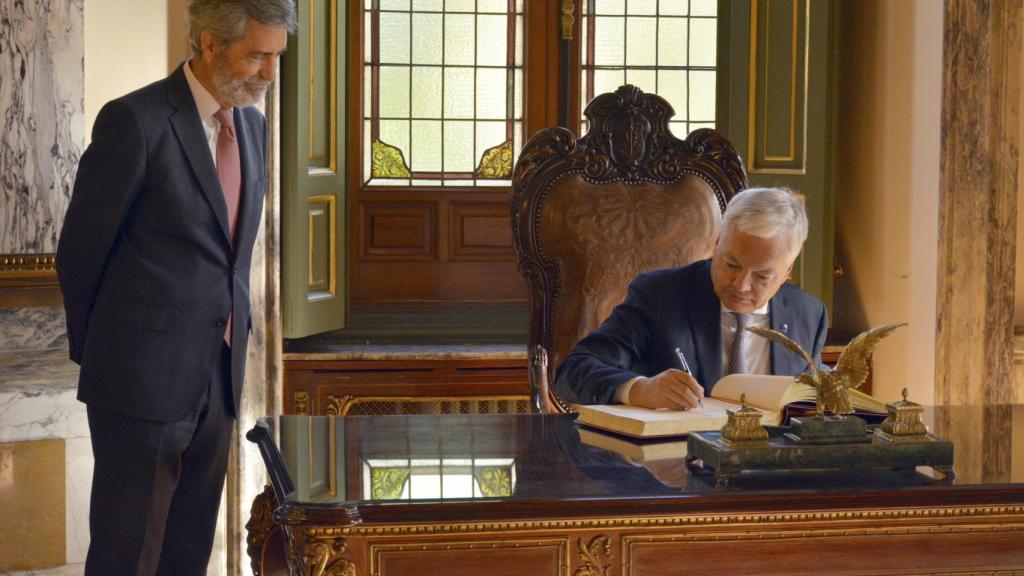 El comisario europeo de Justicia, Didier Reynders, firma en el libro de visitas durante el encuentro mantenido con el presidente del CGPJ, Carlos Lesmes.