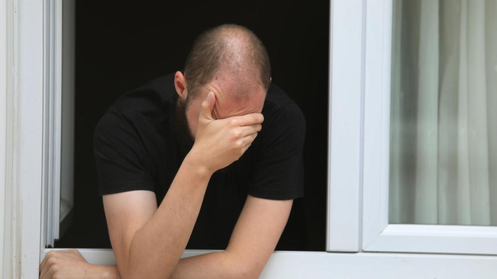 Un joven en la ventana de su domicilio