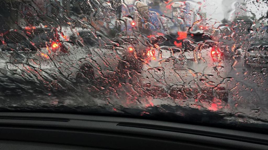 Un coche circulando durante un día de lluvia.