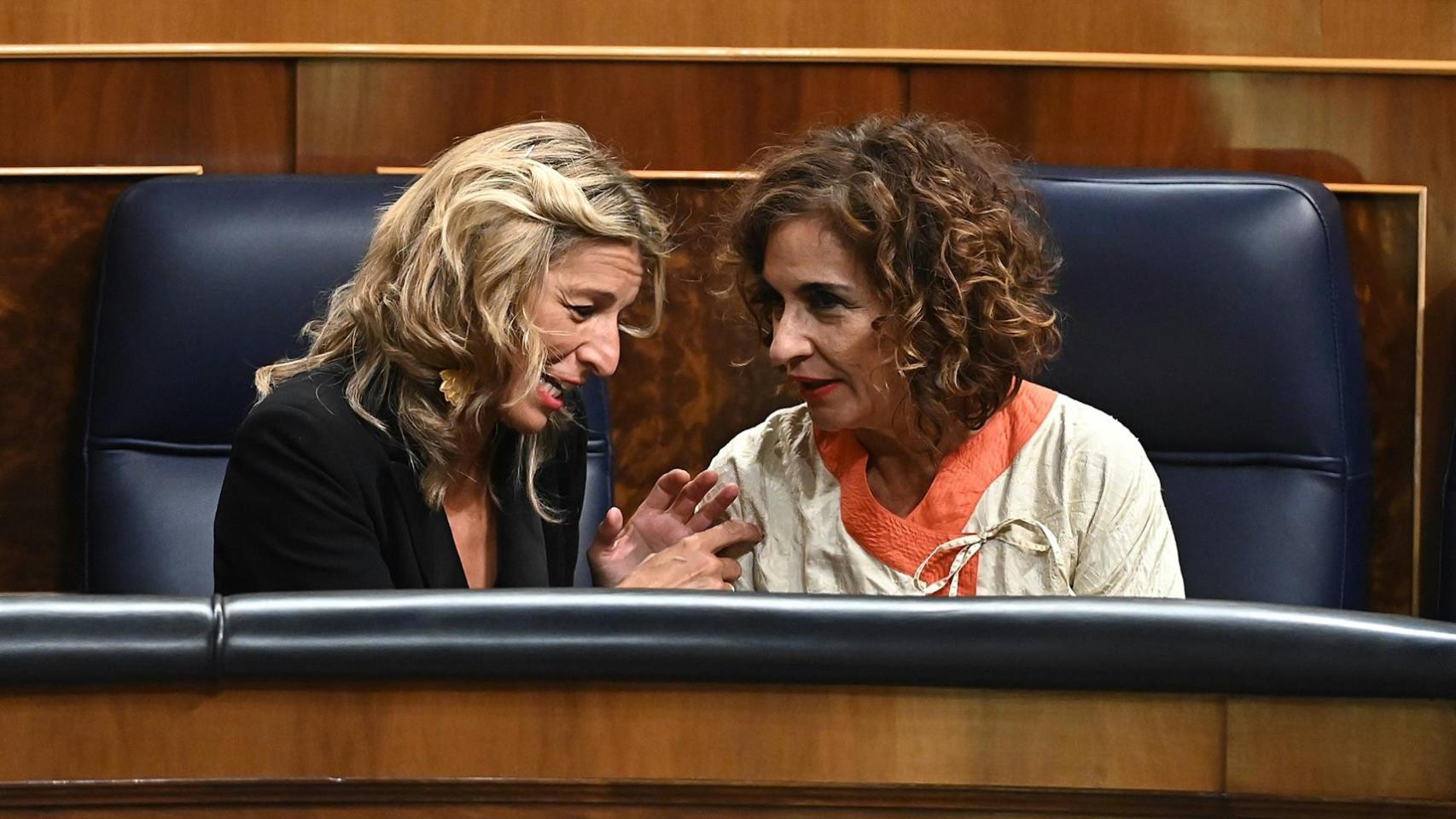 La vicepresidenta segunda y ministra de Trabajo y Economía Social, Yolanda Díaz (i), conversa con la ministra de Hacienda, María Jesús Montero (d), este martes en el Congreso.