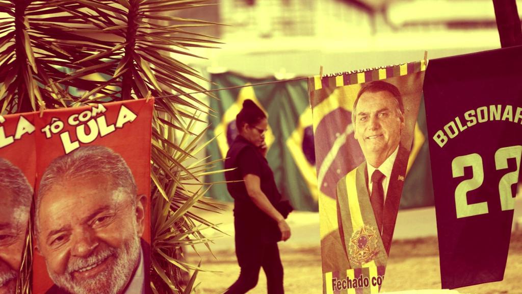 Una mujer camina entre carteles electorales durante la campaña presidencial en Brasil.