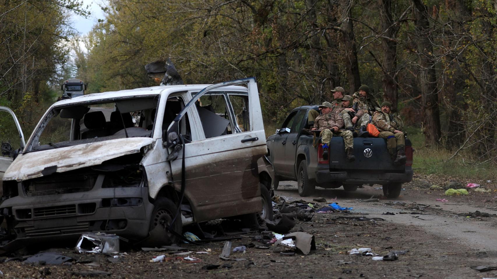Soldados del ejército ucraniano pasan junto a una furgoneta blanca tras tomar la ciudad de Limán.