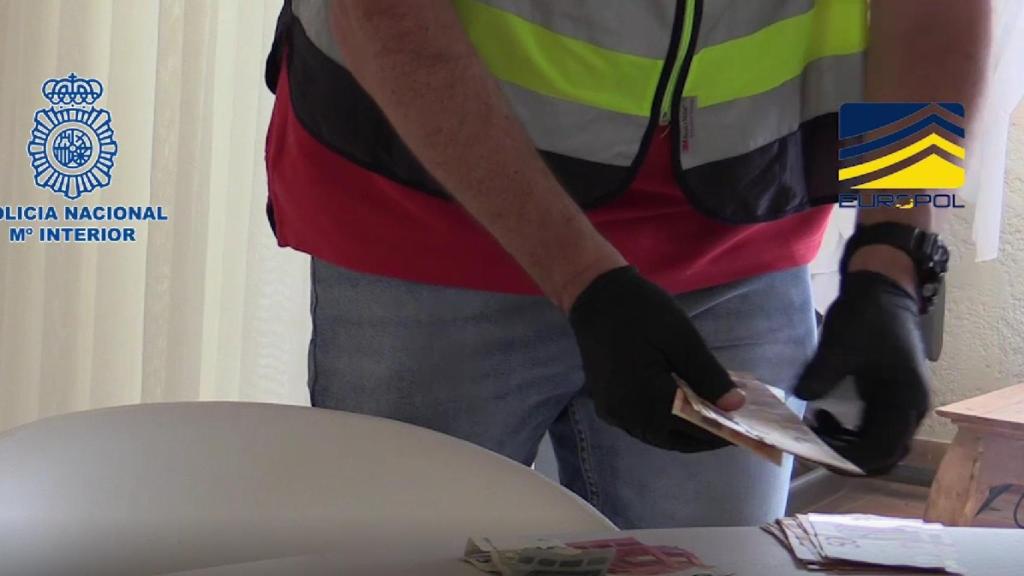 Un agente contando los billetes decomisados.