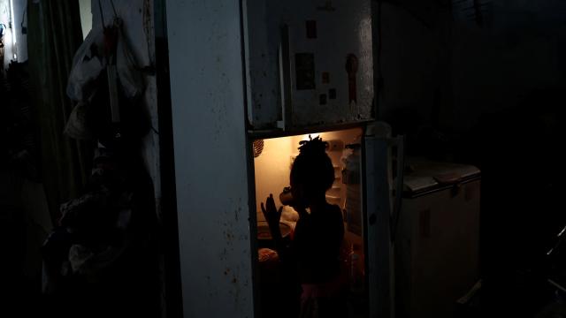 Una niña bebe agua en el frigorífico de su casa en las favelas Arco Iris en Recife (Brasil).