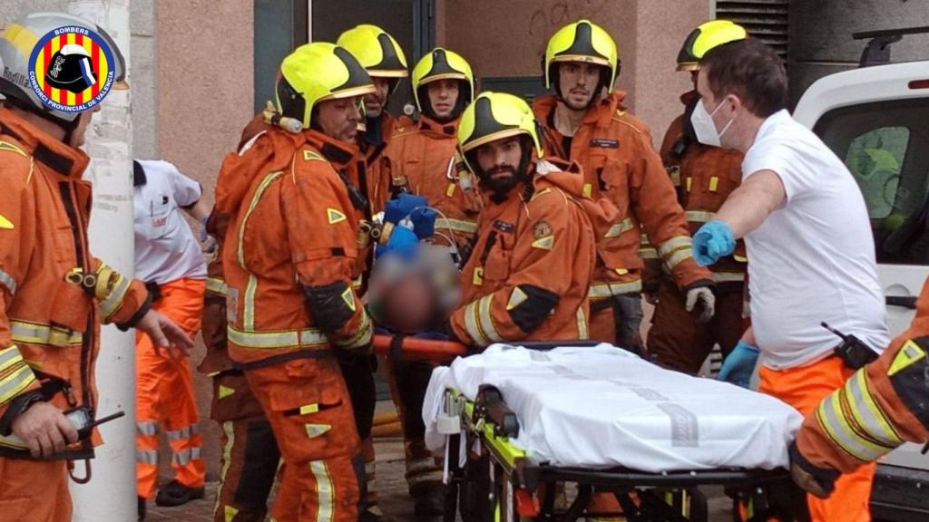 Los bomberos trasladan el cuerpo de la mujer.