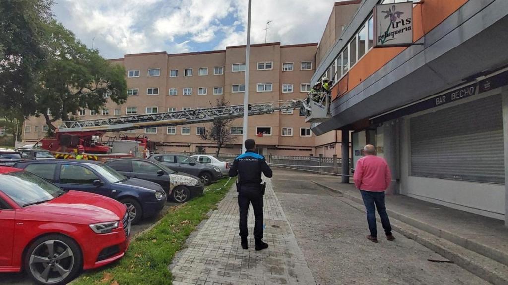 Policía y bomberos de A Coruña aseguran un letrero en la plaza Escultor Mon Vasco.