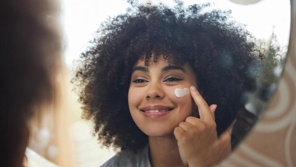 Una chica echándose crema.