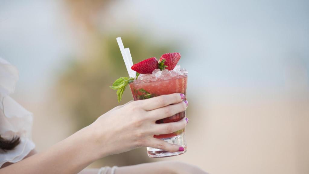 Una mujer disfruta de un daiquiri de fresa.