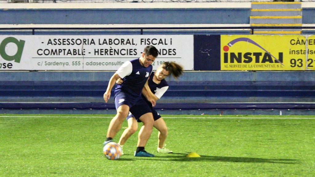 Álex pelea el balón con una compañera.