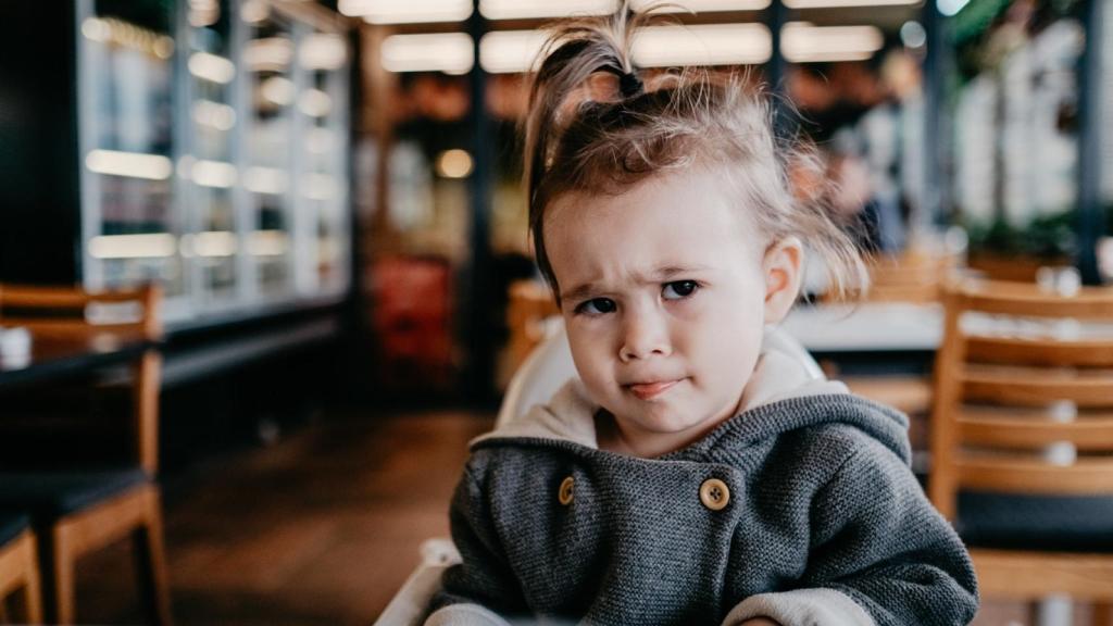Una niña enfadada en un restaurante.