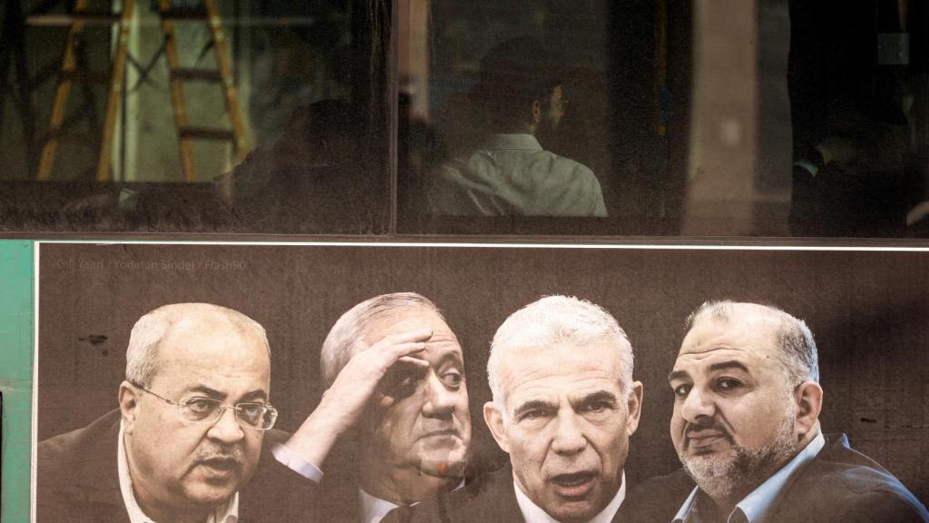 Un cartel de la campaña electoral que representa al primer ministro israelí Yair Lapid entre otros políticos se ve en un autobús en Jerusalén.