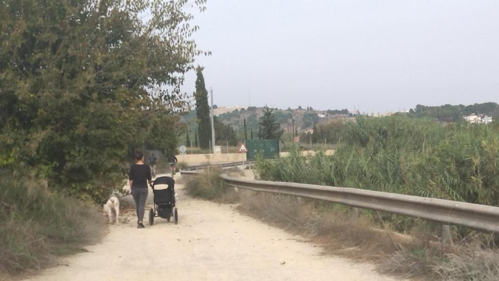 Una vecina y un par de ciclistas, este lunes, por la mota del río Segura en la pedanía murciana de Javalí Nuevo.