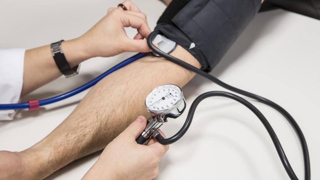Un profesional mide la tensión arterial.