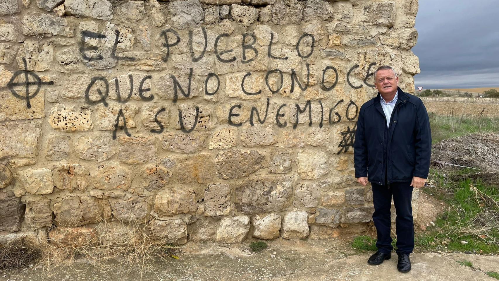 El alcalde Lorenzo Rodríguez posa ante una pintada antisemita.