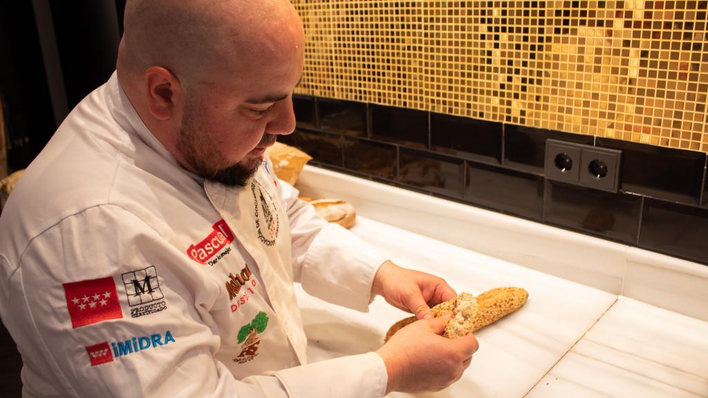Julio López, observando los cereales de la corteza del pan.