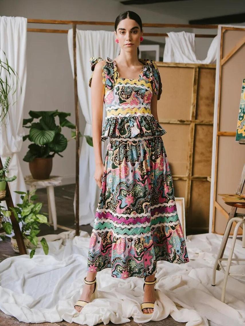 Conjunto estampado en tonos lavanda formado por una falda midi con cenefas en el bajo en color blanco, magenta y verde agua, y otra en color amarillo que marca la cintura.