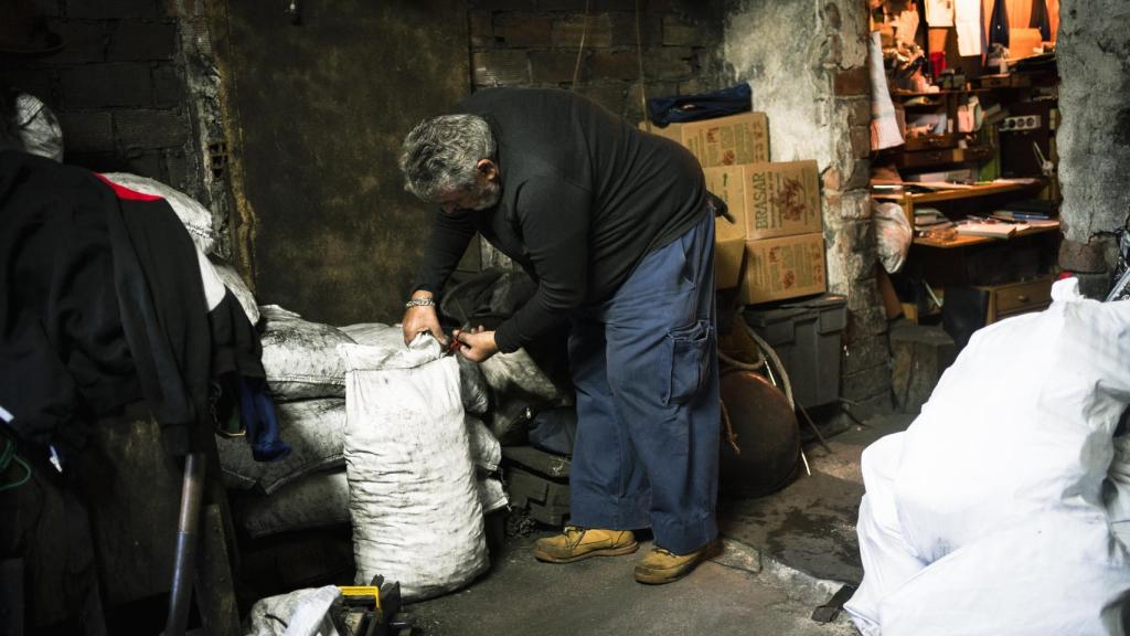 Javier, entre los sacos de carbón que reparte.