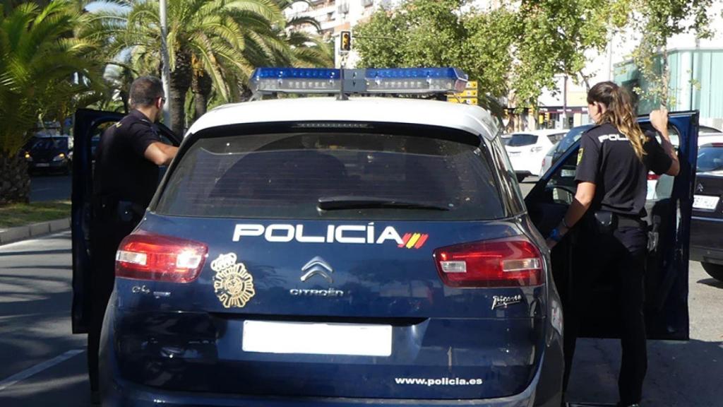 Vehículo y agentes de la Policía Nacional.