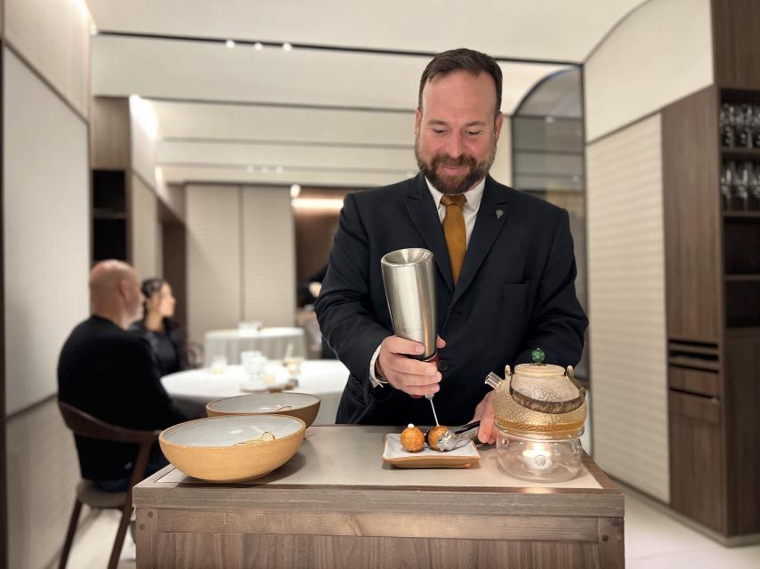 Eric Vicente, sumiller y jefe de sala de Cinc Sentits, acaba un plato en sala