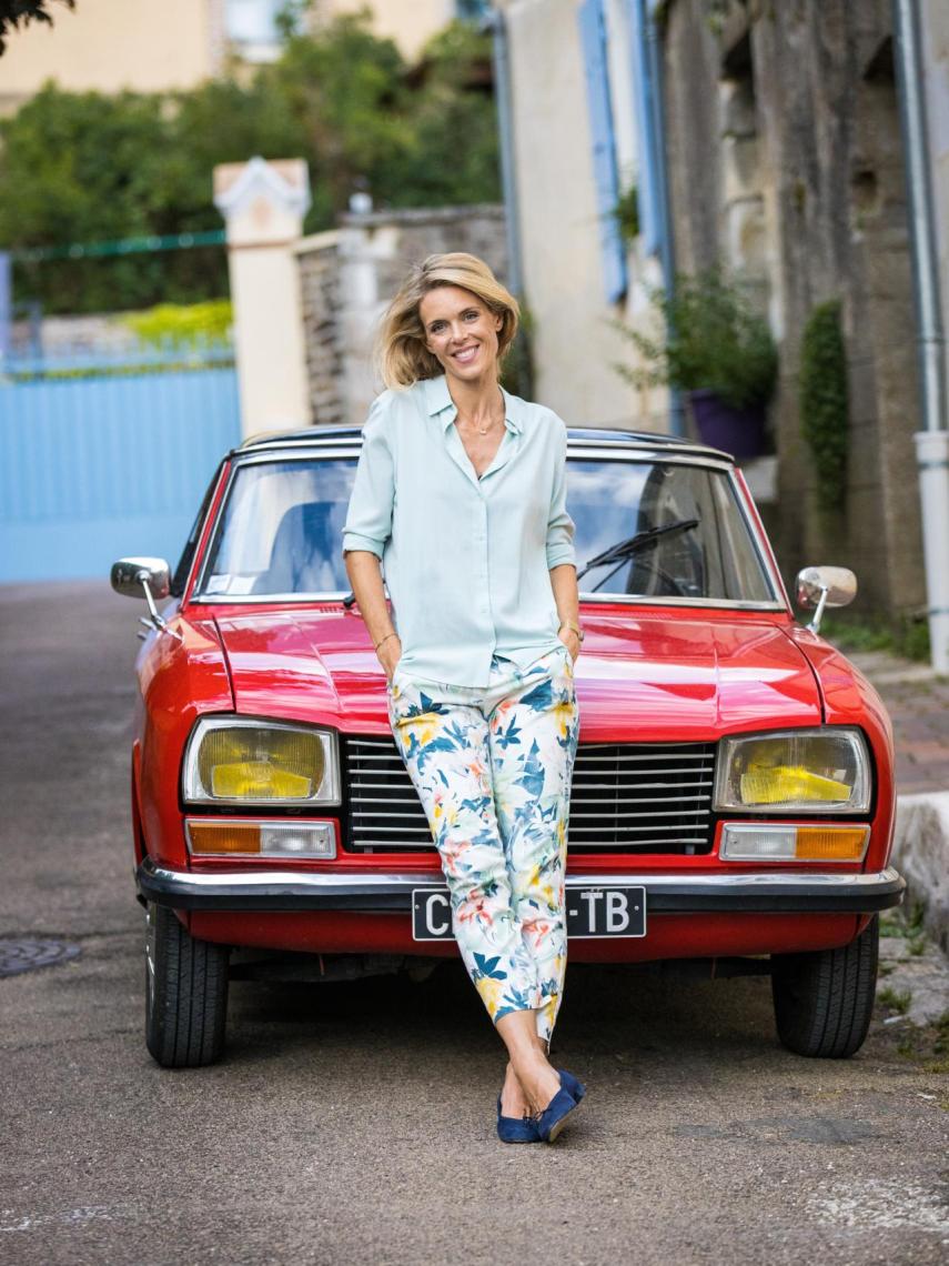Julie delante de su coche descapotable rojo icono del programa.
