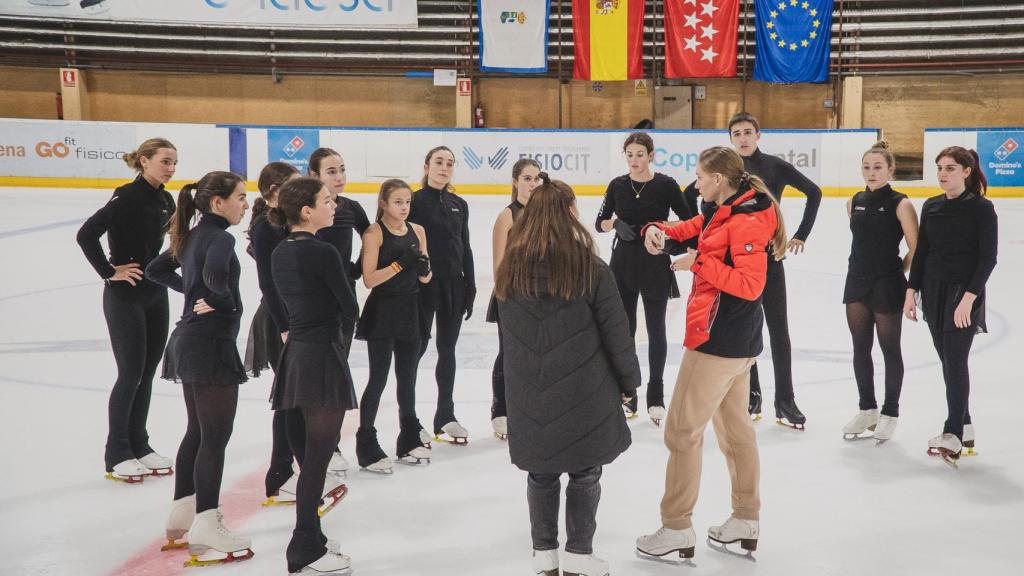 La entrenadora da instrucciones a las patinadoras.
