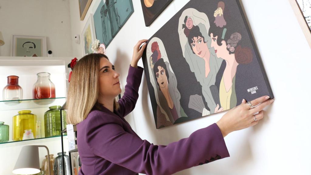 La ilustradora y diseñadora gráfica Mercedes Juan junto a una de sus obras.