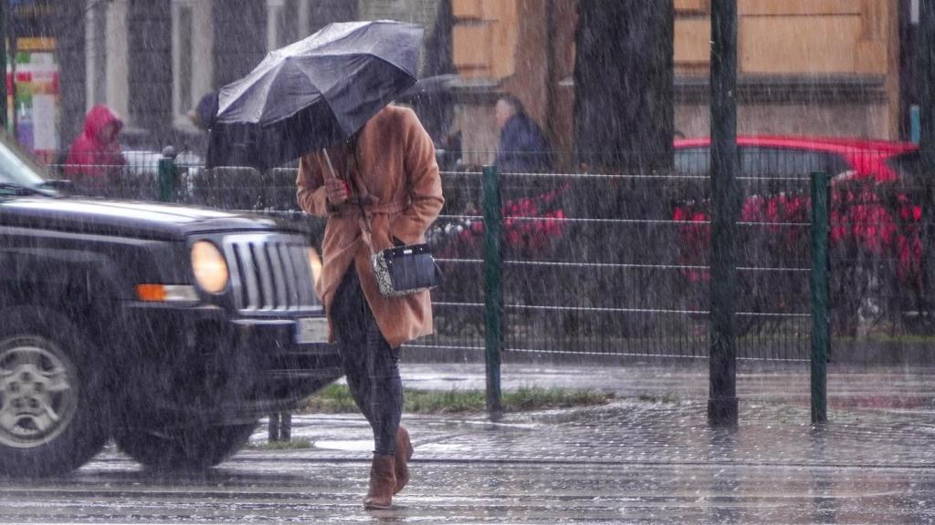 Una mujer pasea bajo la lluvia en una imagen de archivo