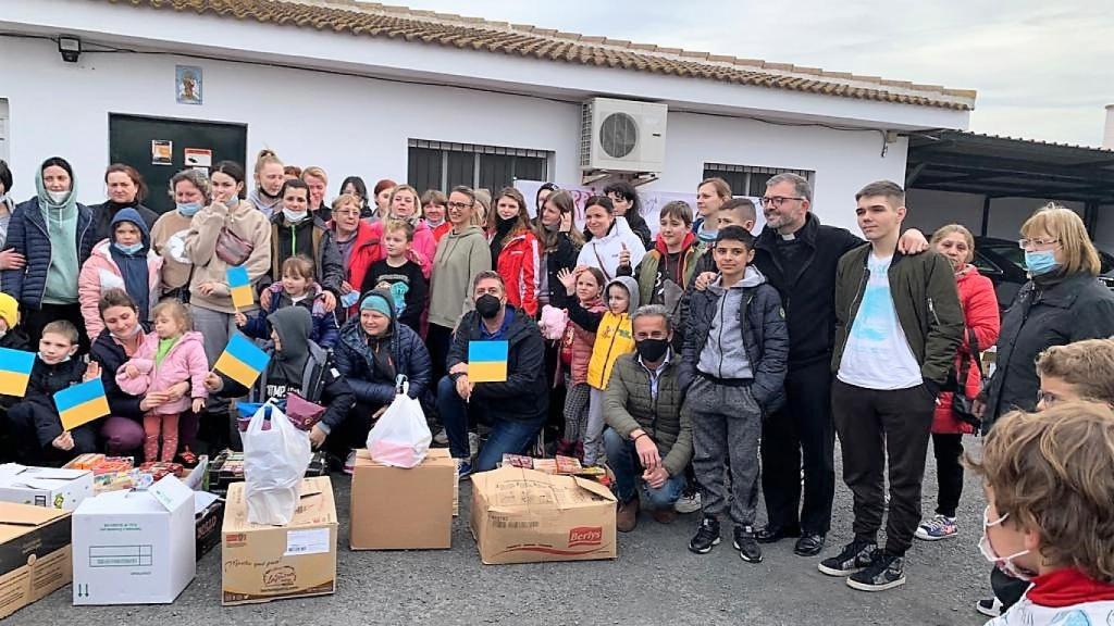 El primer grupo de refugiados de Ucrania al llegar a Gibraleón (Huelva) el 17 de marzo. Juan de Dios Martín está agachado en el centro con mascarilla negra. A su lado, están Ganna, con gorro azul, y su hijo pequeño, Zahar, con capucha; a la derecha de la foto, de pie, con camiseta clara y chaqueta, está el hijo mayor, Vadym.