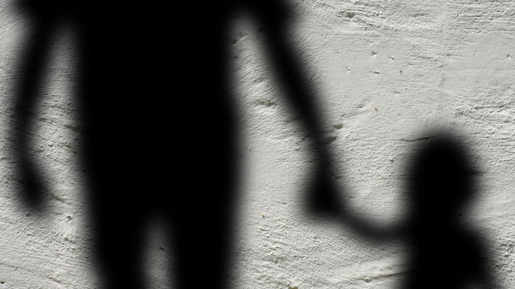 Imagen de archivo de las sombras de un adulto y una niña.