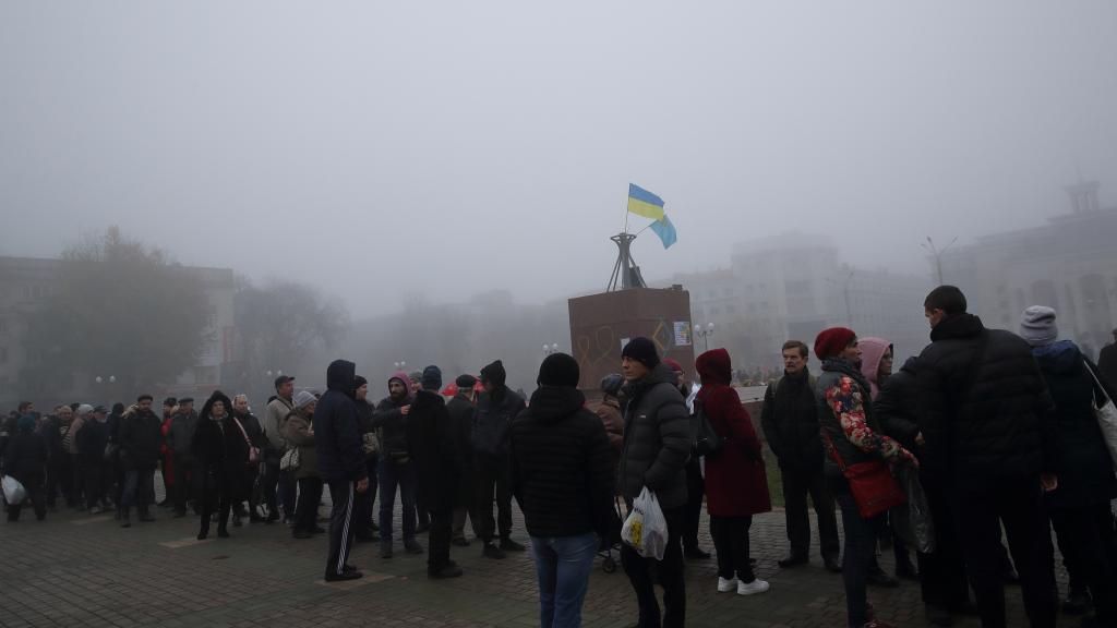 Gente espera en fila para comprar tarjetas SIM en la plaza central de Jersón.