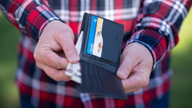 Un hombre sacando dinero de su cartera.