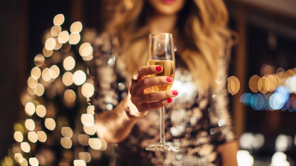 Una mujer sujeta una copa de cava en Nochevieja.