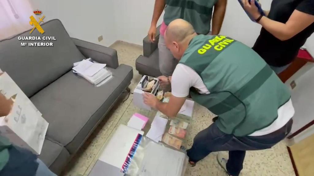 Un guardia civil contando dinero en metálico durante uno de los registros.