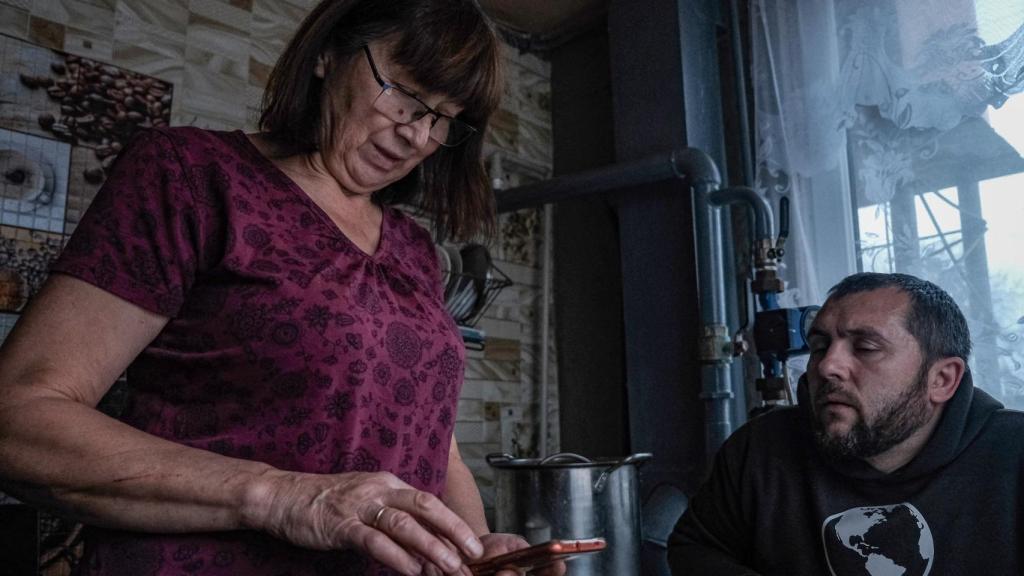 Olga, la abuela de Katia, le muestra a Sasha unas pruebas médicas que le han enviado a su teléfono.