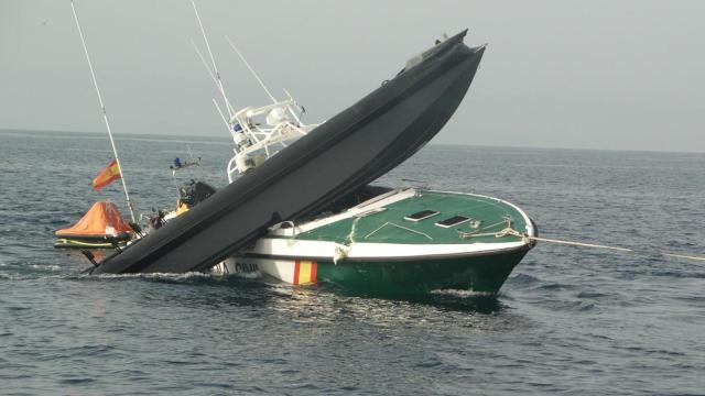 Una de las patrulleras de la Guardia Civil debajo de una narcolancha.
