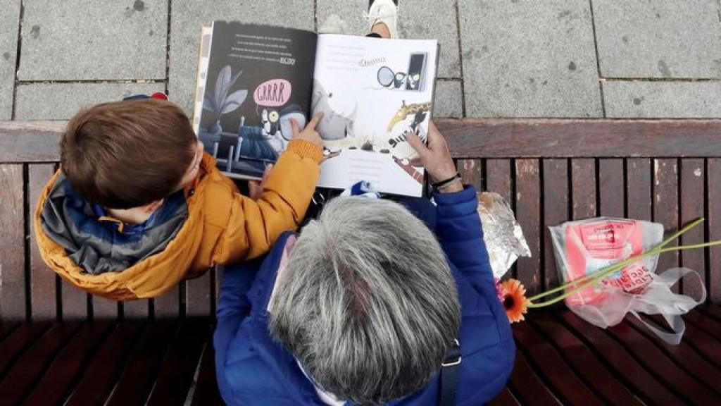 Un niño leyendo junto a su abuela.