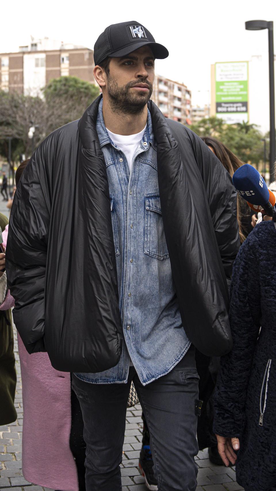 El exfutbolista Gerard Piqué llegando a su cita ante el juez, con rostro serio y gorra calada.
