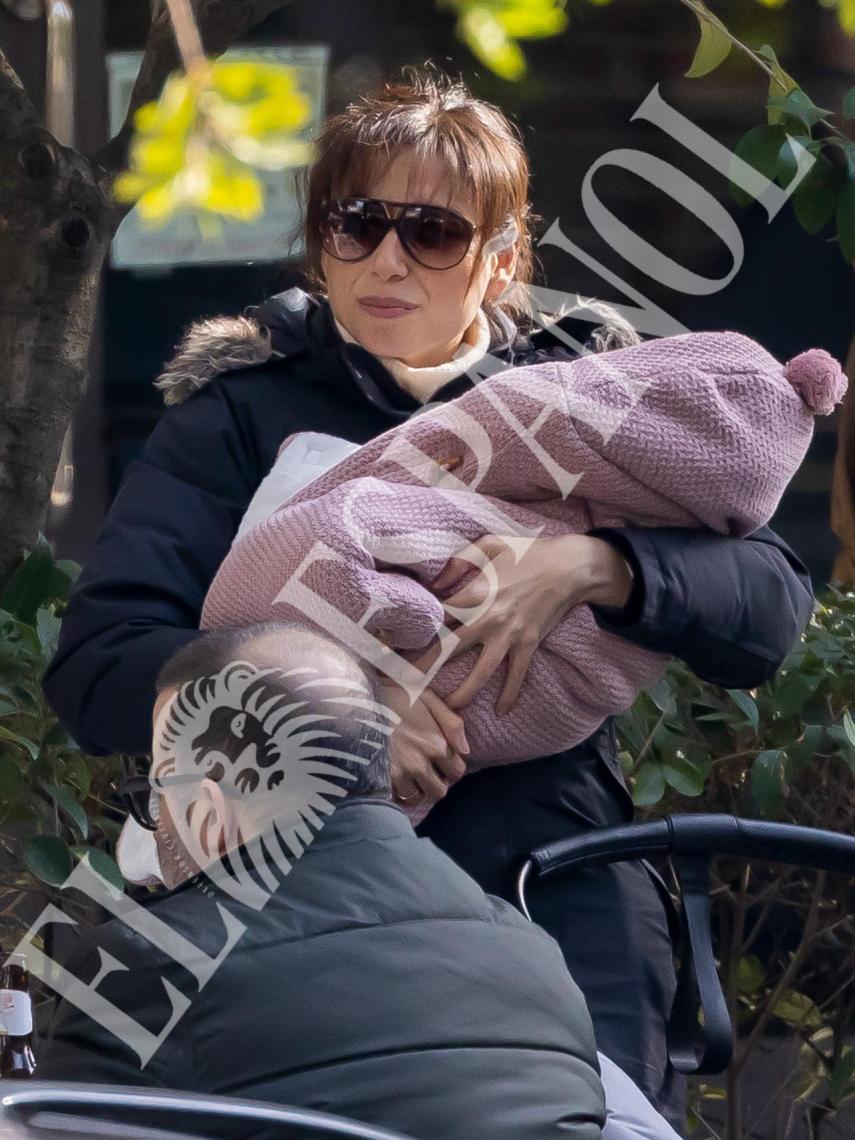 Marta Flich, sonriente, mientras porta a su hija en brazos.