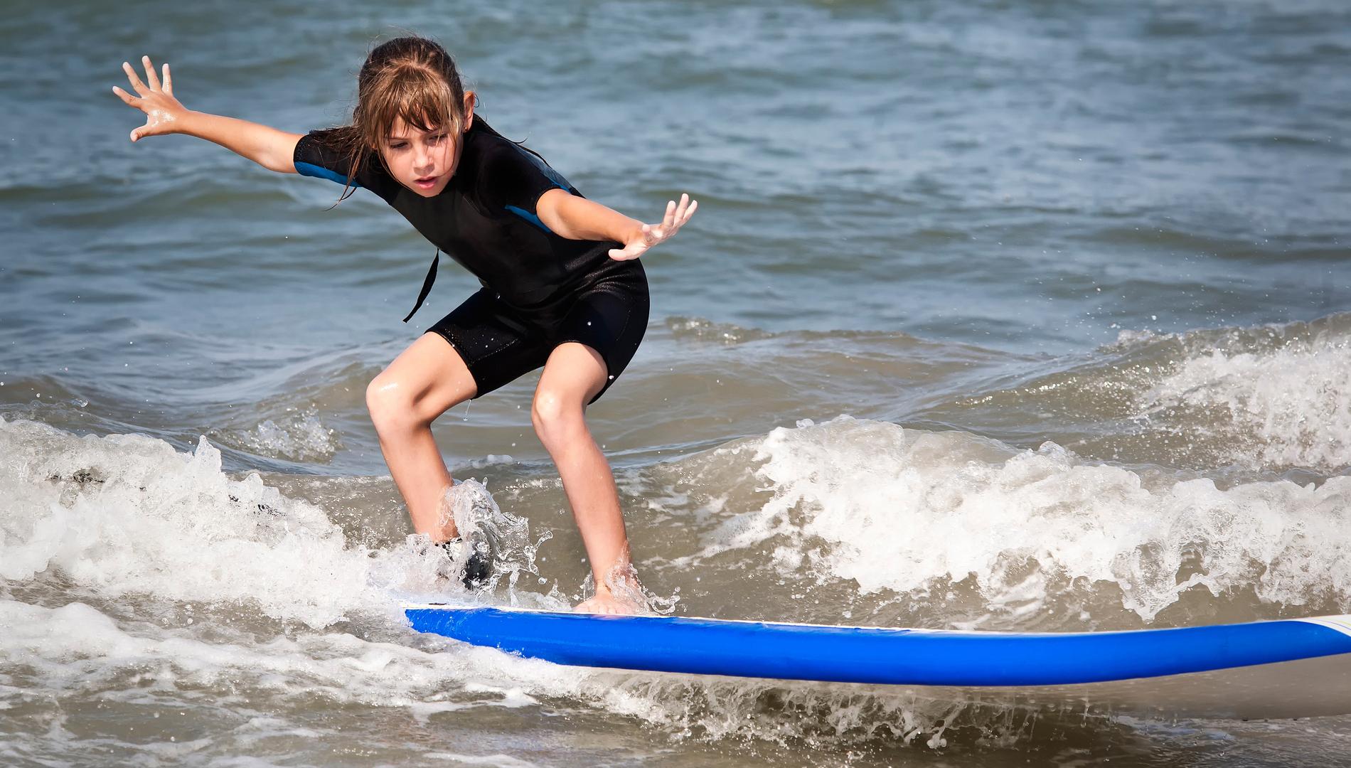 Niña practicando surf.