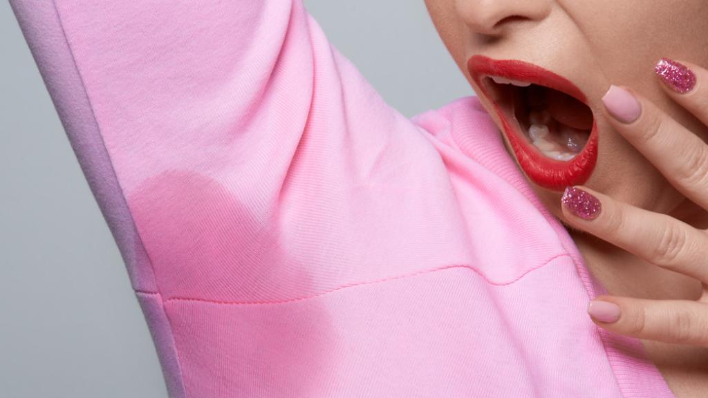 Mujer mostrando sudor en su blusa.